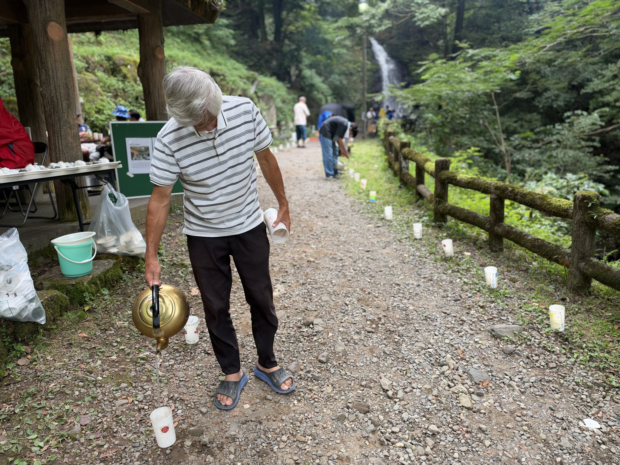 地域の方がやかんでローソクカップに水を注いでいきます。